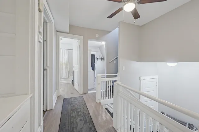 a view of a hallway with wooden floor and staircase