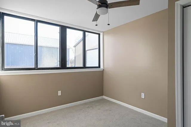 a work room with furniture wooden floor and a large window