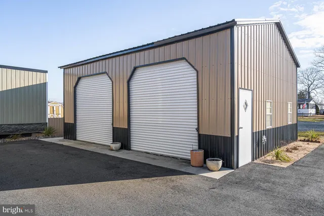 a view of a kitchen with a refrigerator a ceiling fan and wooden floor