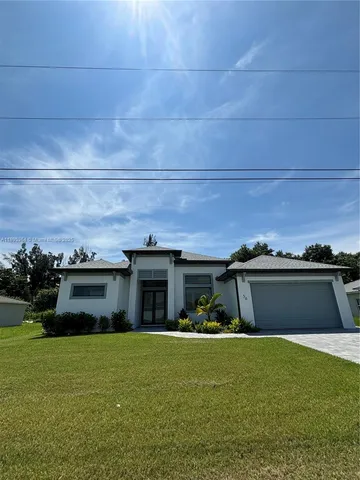a front view of house with yard and car parked