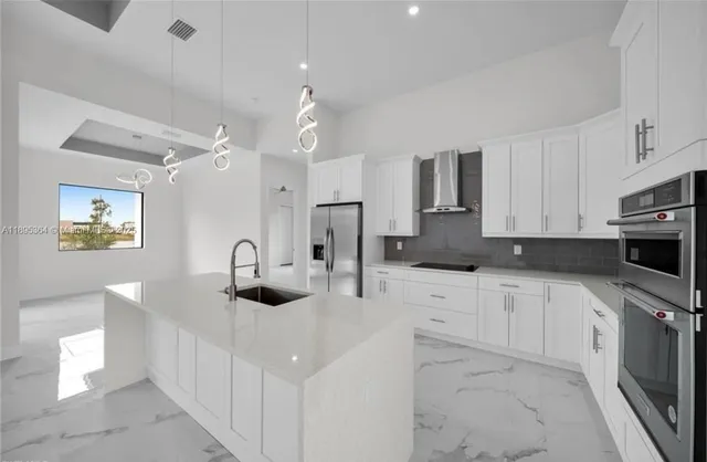 a kitchen with stainless steel appliances kitchen island granite countertop a sink and cabinets