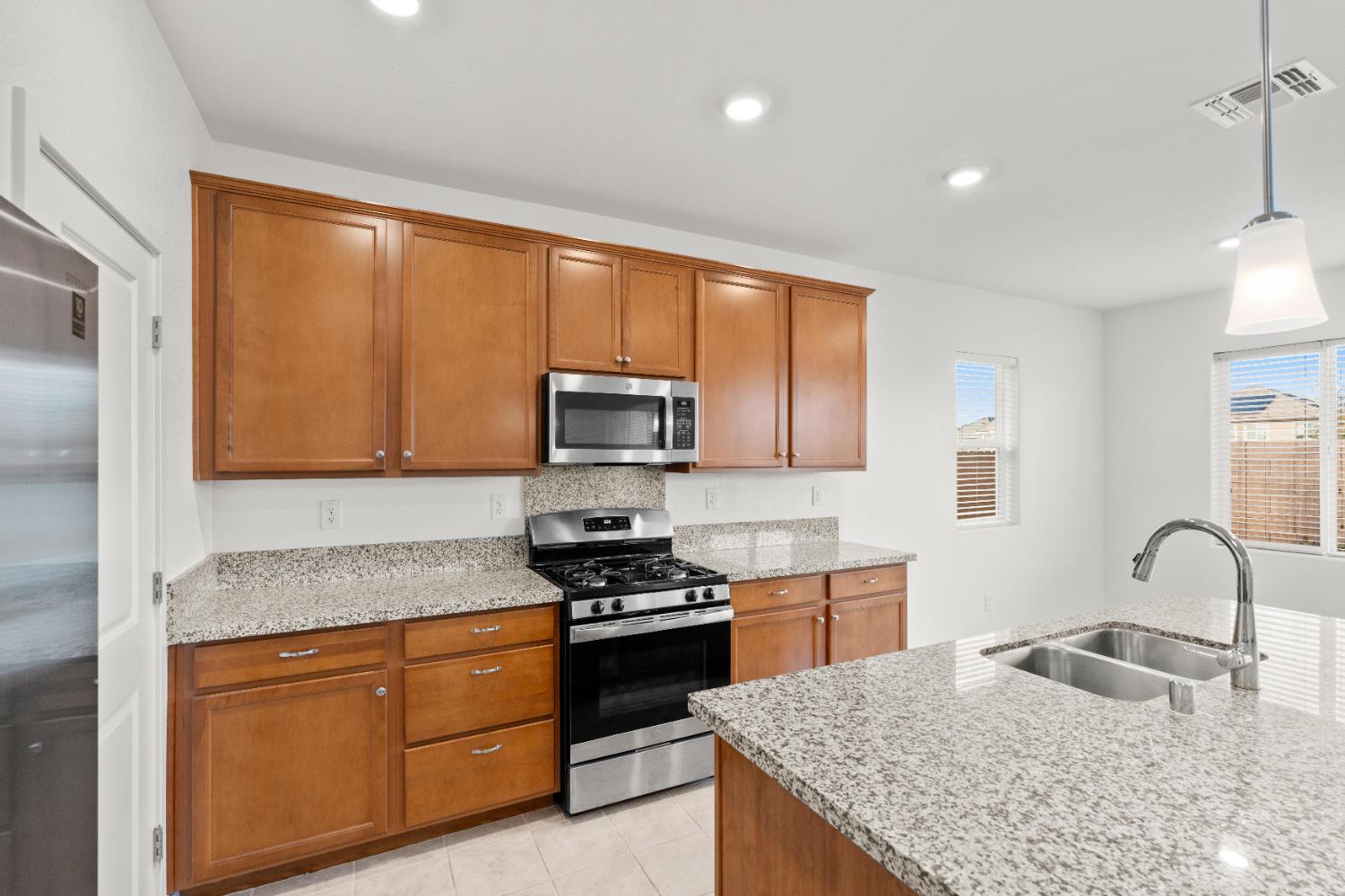 620 River Street Lincoln, CA 95648 - Photo 28 of 60 a kitchen with granite countertop wooden cabinets stainless steel appliances and a window