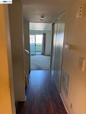 a view of a hallway with wooden floor and glass door