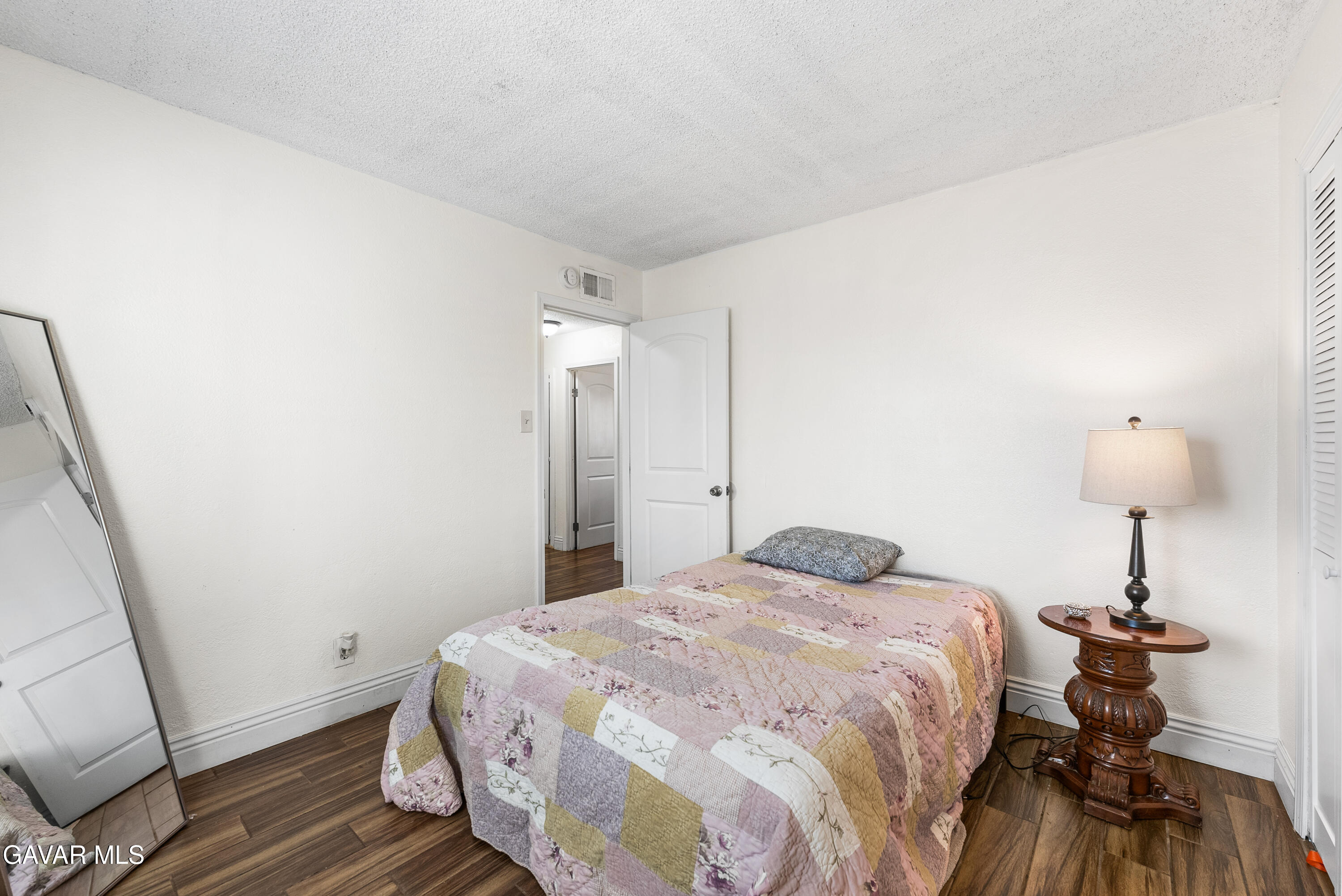 45323 Andale Avenue Lancaster, CA 93535 - Photo 17 of 28 a bedroom with a bed and a mirror