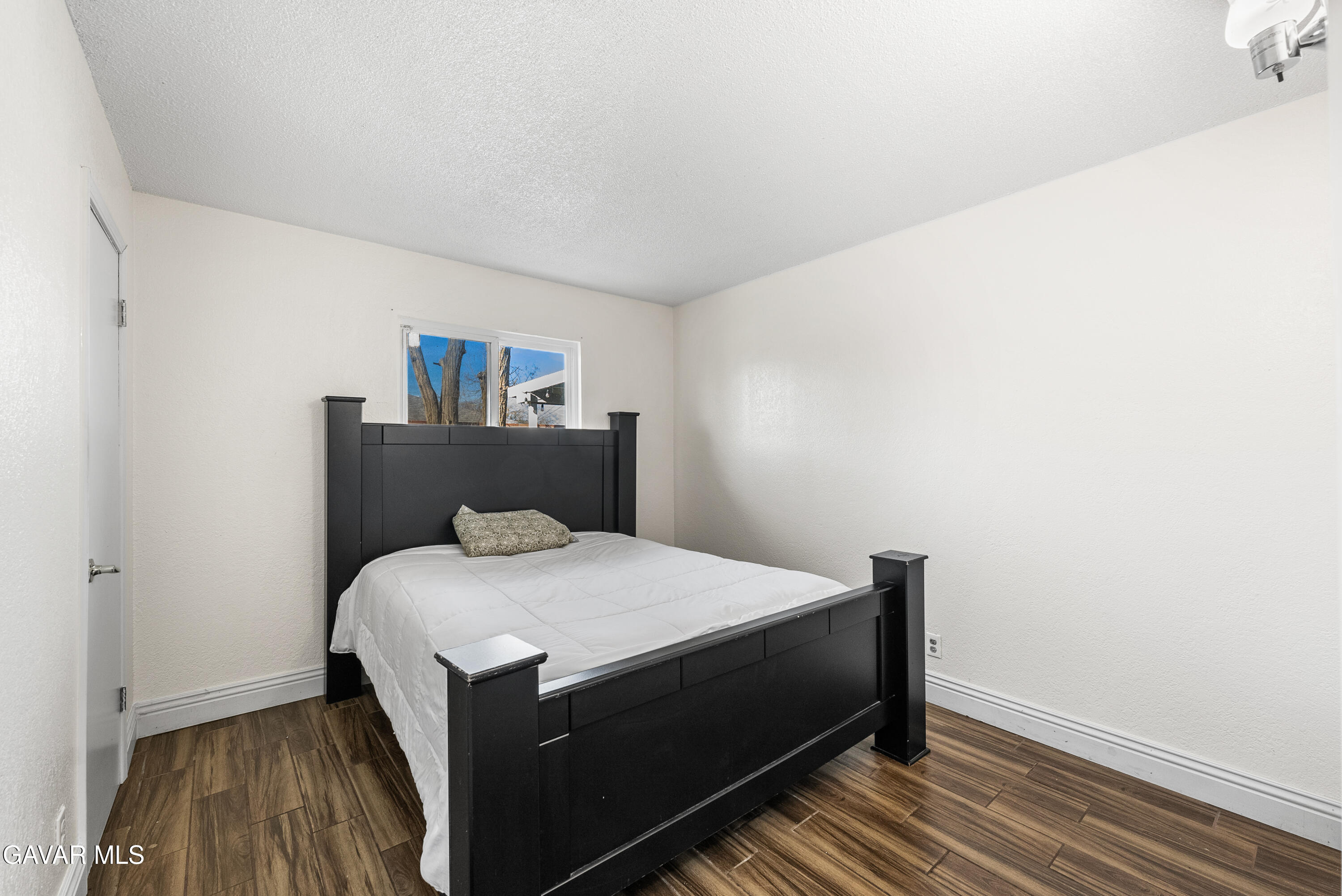 45323 Andale Avenue Lancaster, CA 93535 - Photo 21 of 28 a bedroom with a bed and wooden floor