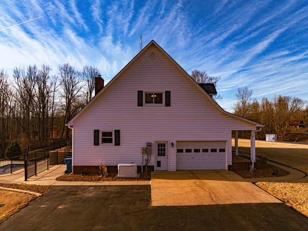 a front view of house with yard and trees in the background