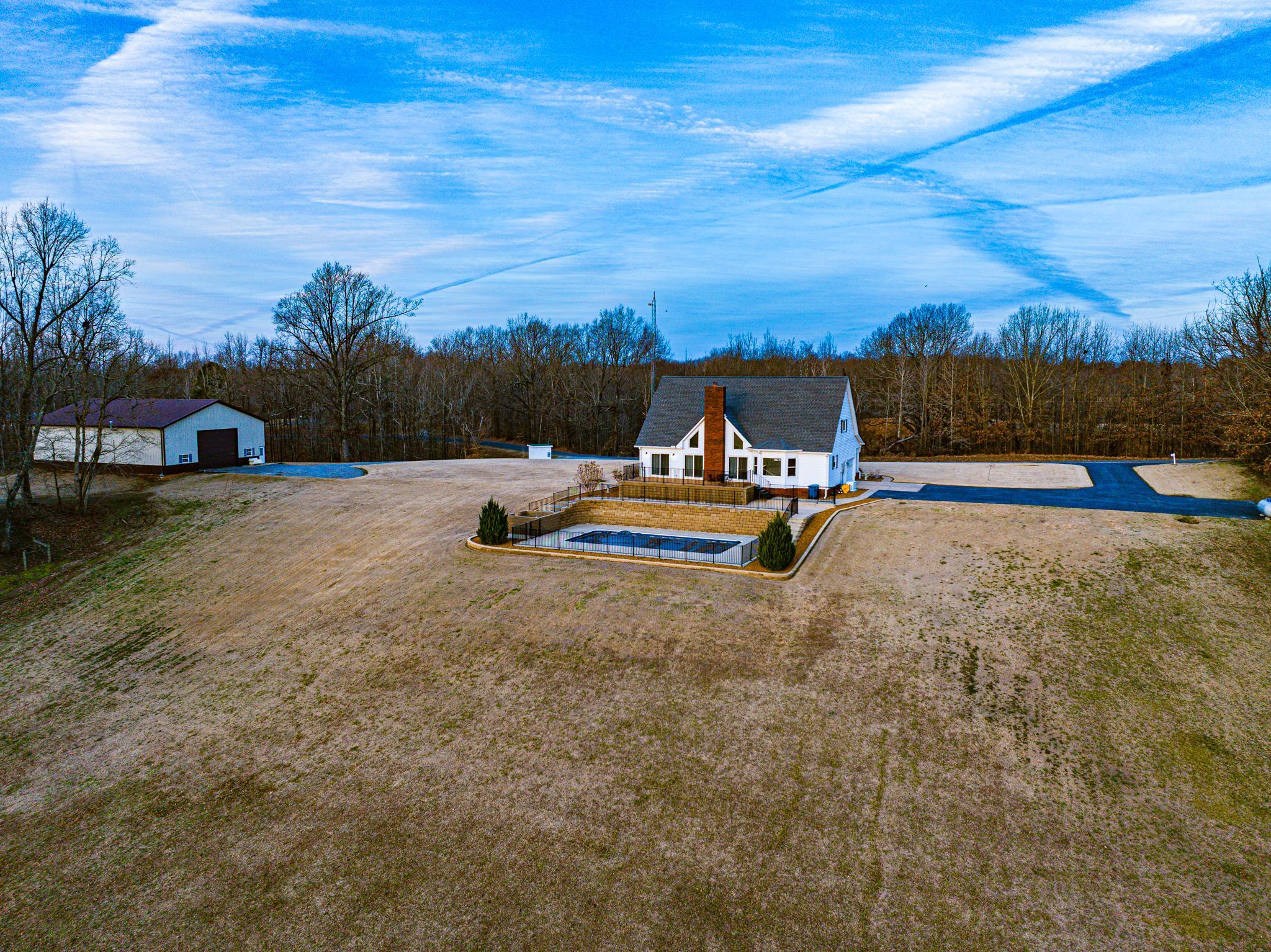 5030 Rogers Marshall Road Union City, TN 38261 - Photo 23 of 40 View of green lawn featuring an outdoor structure, driveway, a garage, and a swimming pool