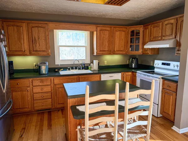 a kitchen with stainless steel appliances granite countertop a stove a sink and a microwave