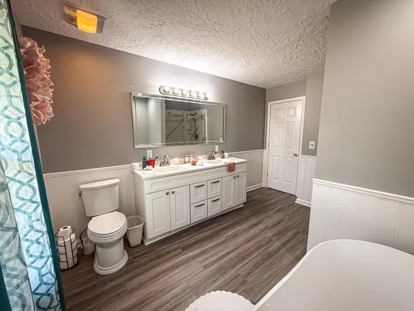 a bathroom with a toilet sink and mirror