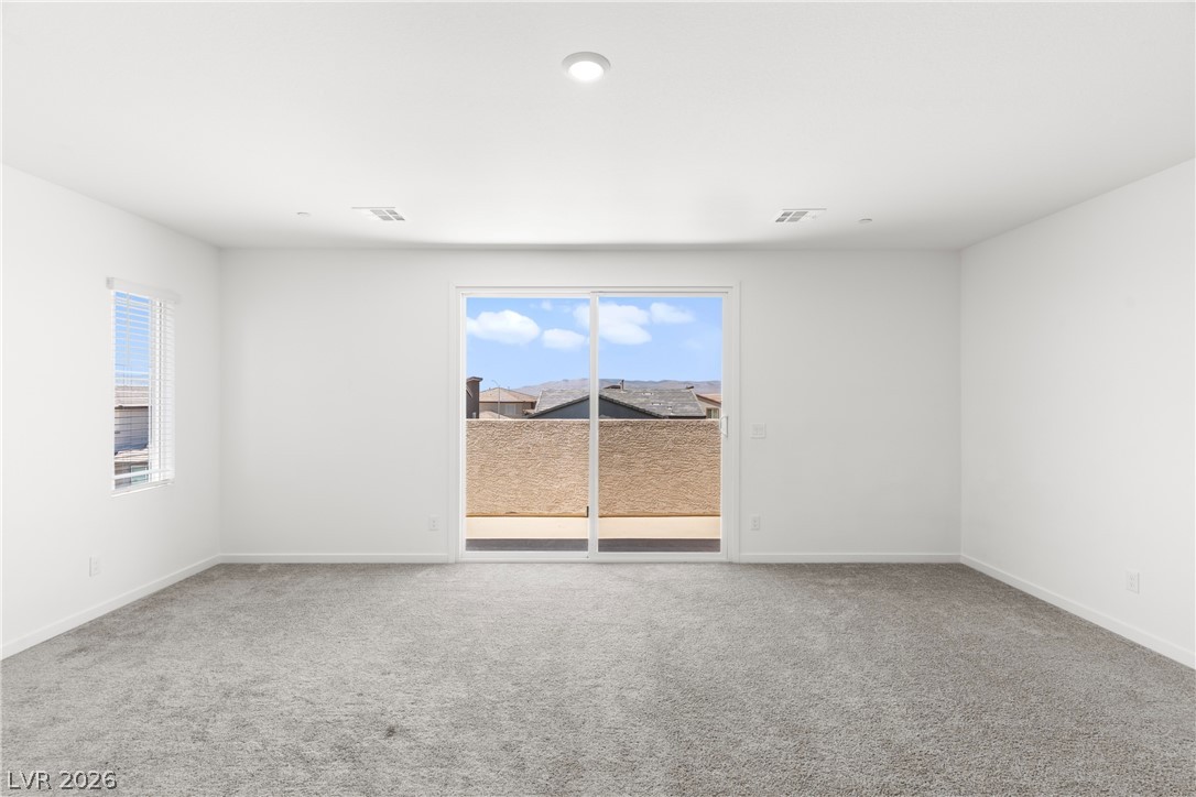 320 Isla Enclave Way Henderson, NV 89011 - Photo 25 of 49 This airy primary bedroom features ample natural light from a large sliding glass door and a side window, offering mountain views.