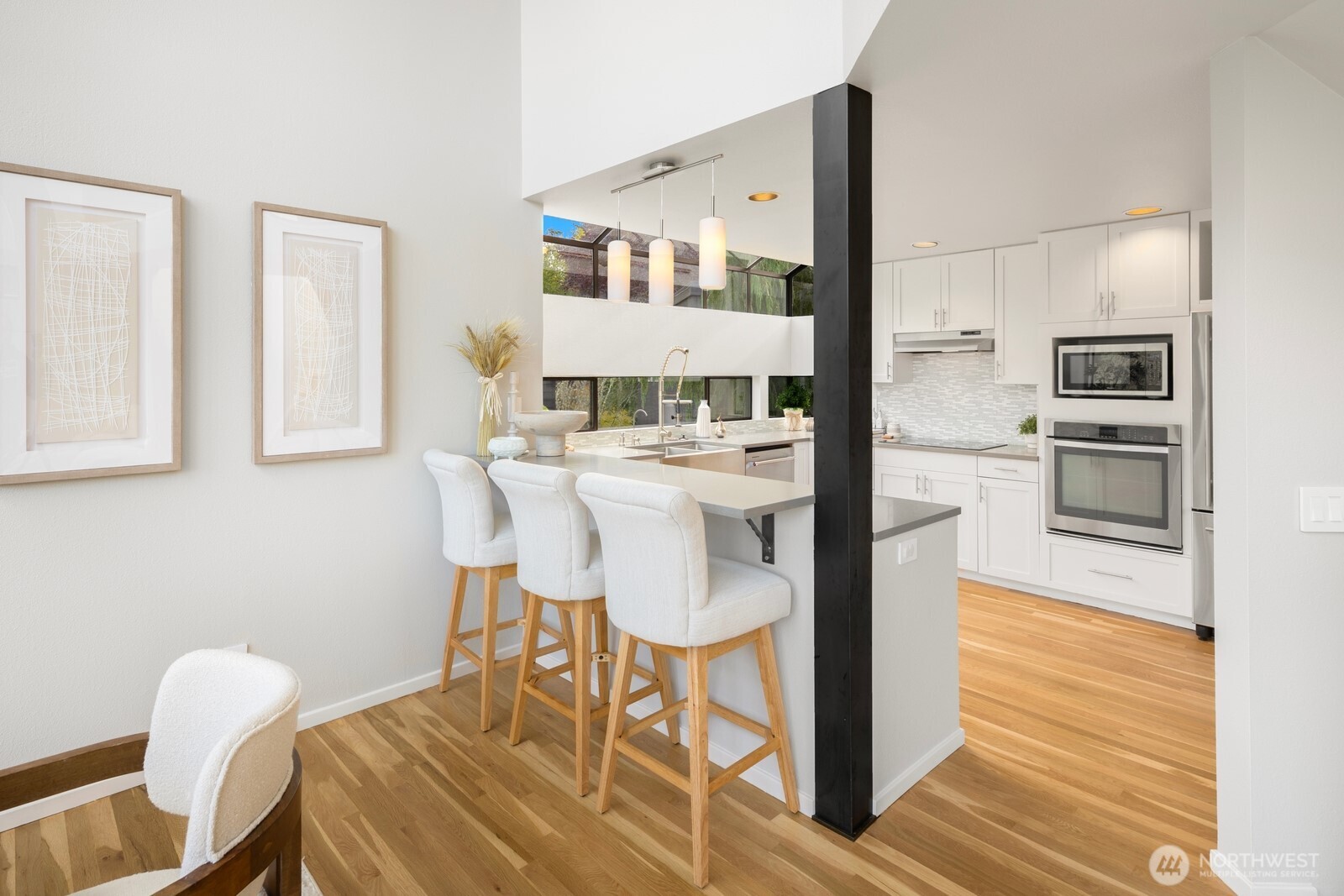 1932 Northwest 98th Street Seattle, WA 98117 - Photo 16 of 40 a kitchen with stainless steel appliances kitchen island granite countertop a table chairs and a refrigerator