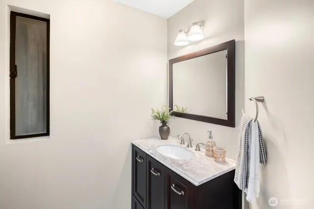 a bathroom with a sink vanity and a mirror