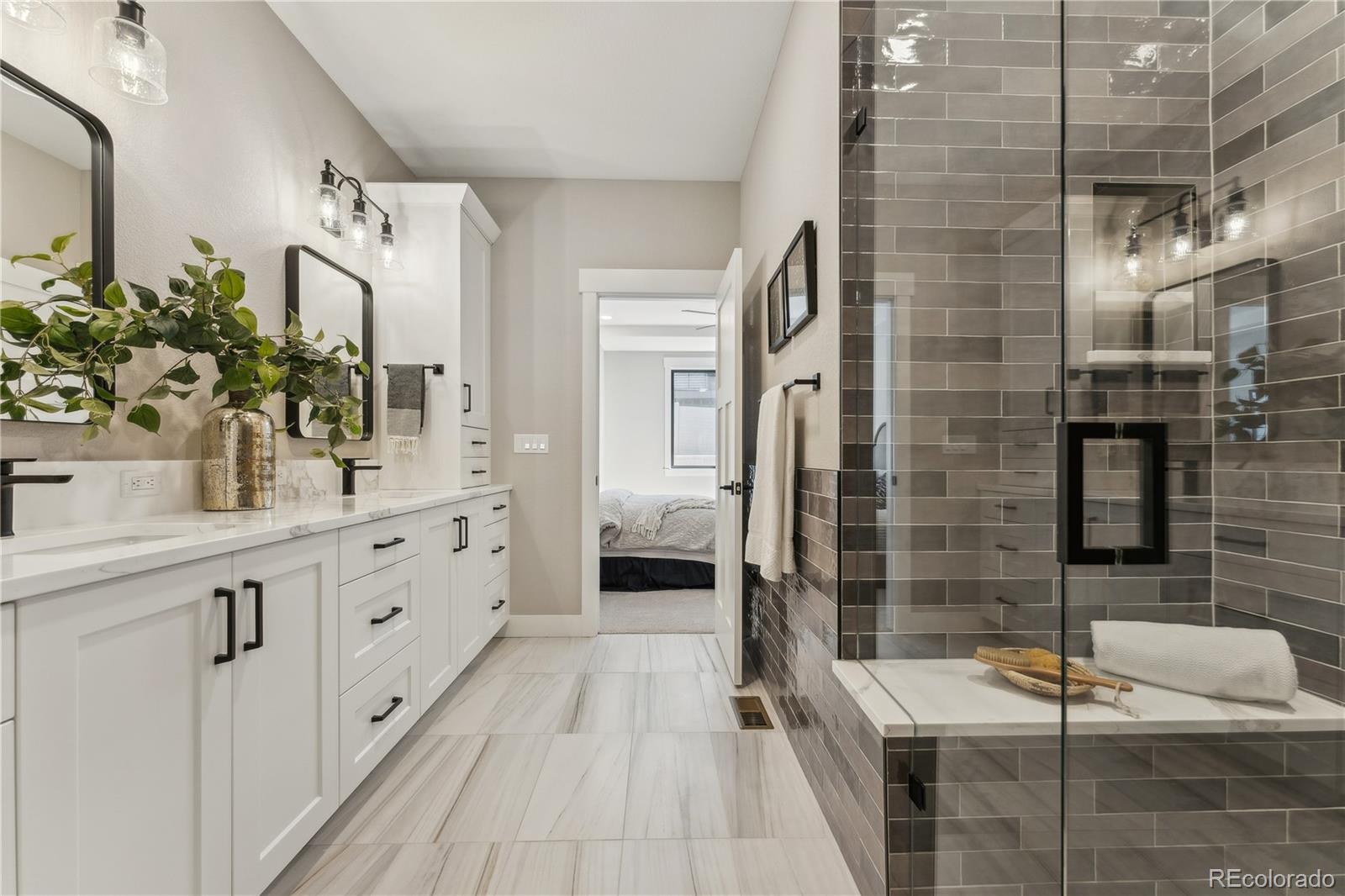 1361 Art Drive Berthoud, CO 80513 - Photo 18 of 40 a bathroom with a double vanity sink a toilet a mirror and shower