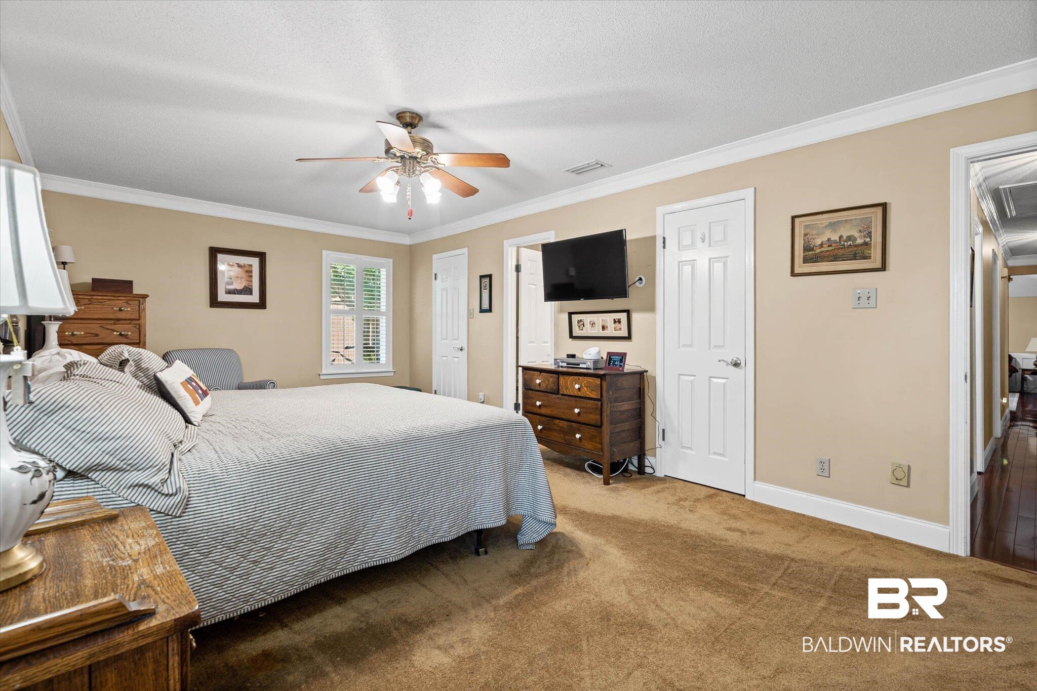 7410 Smithfield Road East Mobile, AL 36695 - Photo 12 of 24 Expansive carpeted room featuring a ceiling fan, crown molding, double window with blinds, and white panel doors