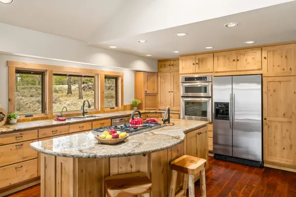 a kitchen with stainless steel appliances granite countertop a sink and a refrigerator