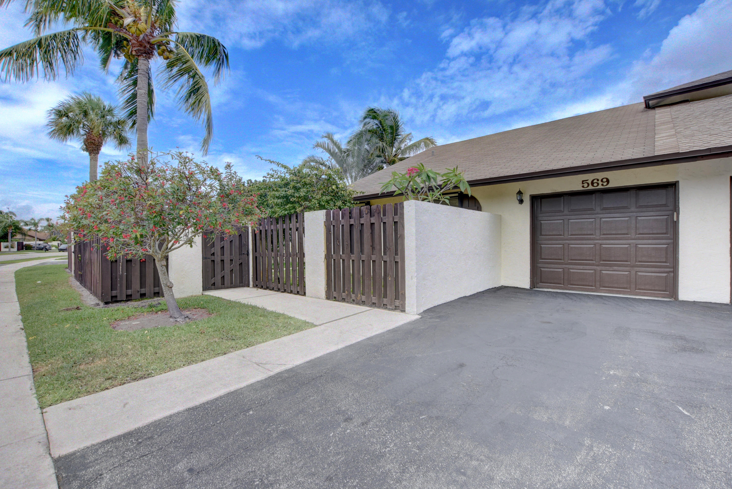 569 Southwest 28th Avenue Delray Beach, FL 33445 - Photo 2 of 25 a view of a house with a yard and garage