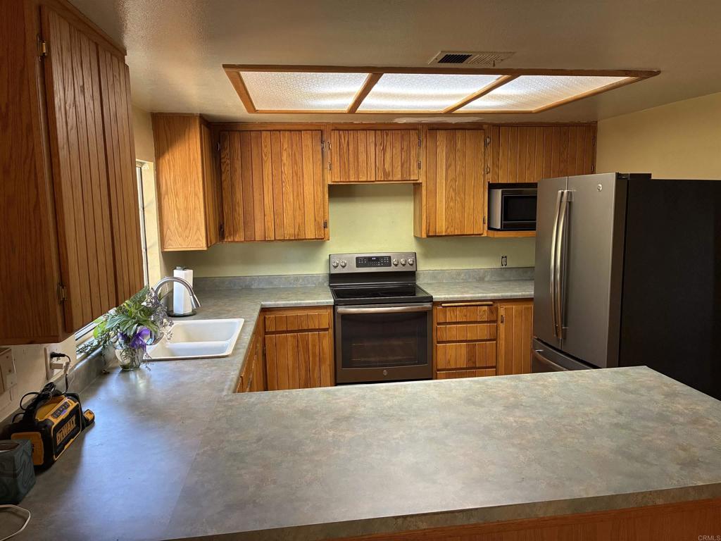 2367 Marshall Way Alpine, CA 91901 - Photo 5 of 13 a kitchen with granite countertop wooden cabinets and stainless steel appliances