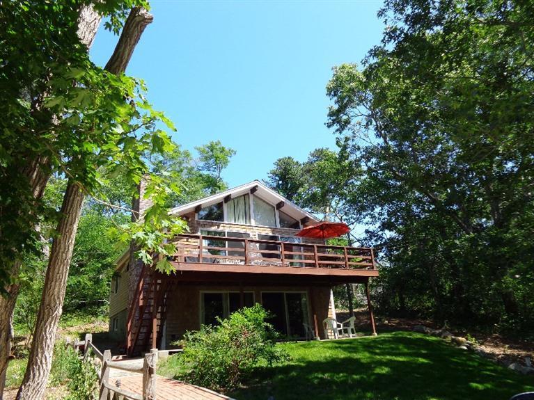 150 Cove View Road Wellfleet, MA 02667 - Photo 1 of 35 a front view of a house with a garden