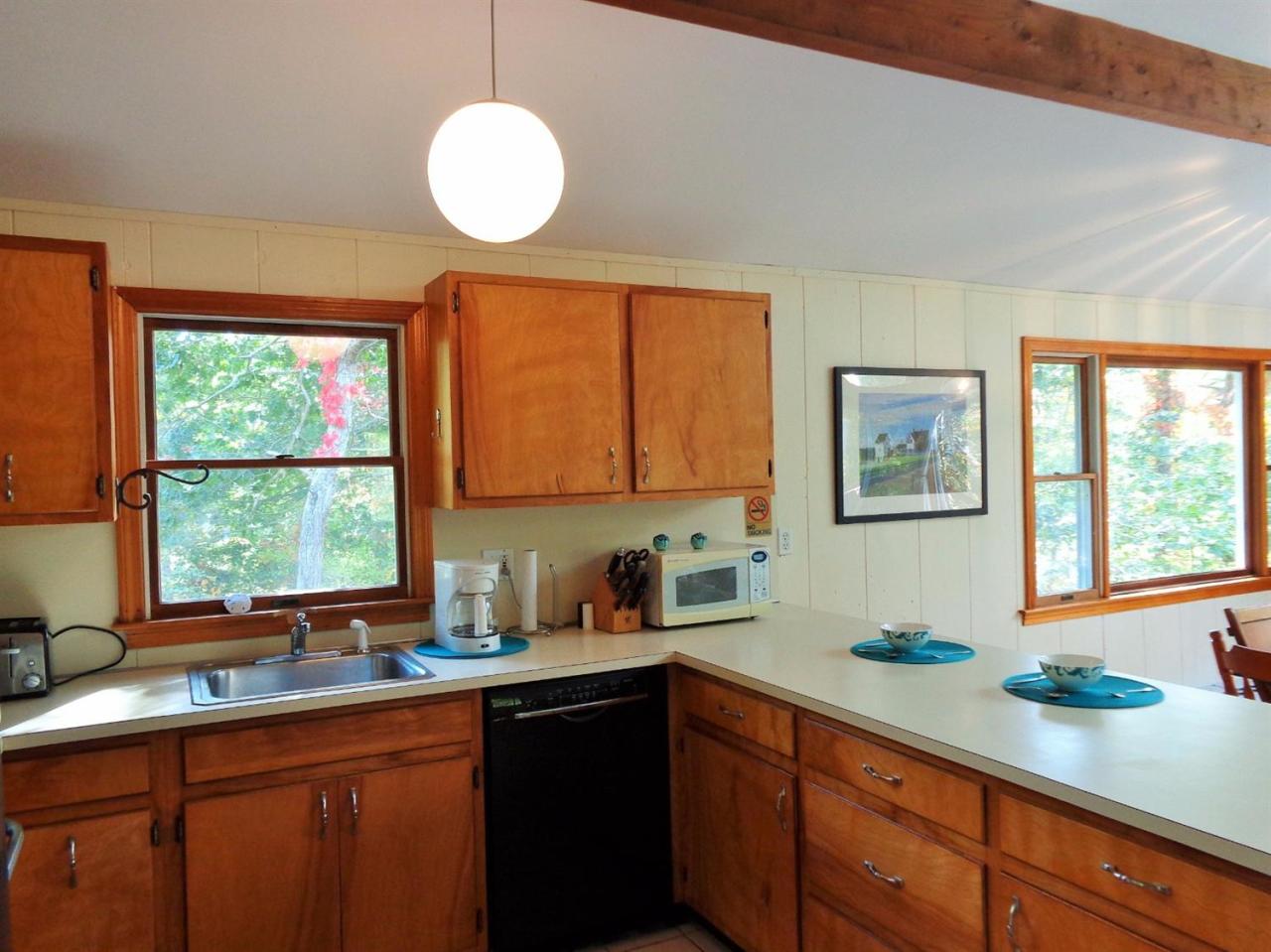 150 Cove View Road Wellfleet, MA 02667 - Photo 4 of 35 a kitchen with stainless steel appliances a sink a large window cabinets and a sink