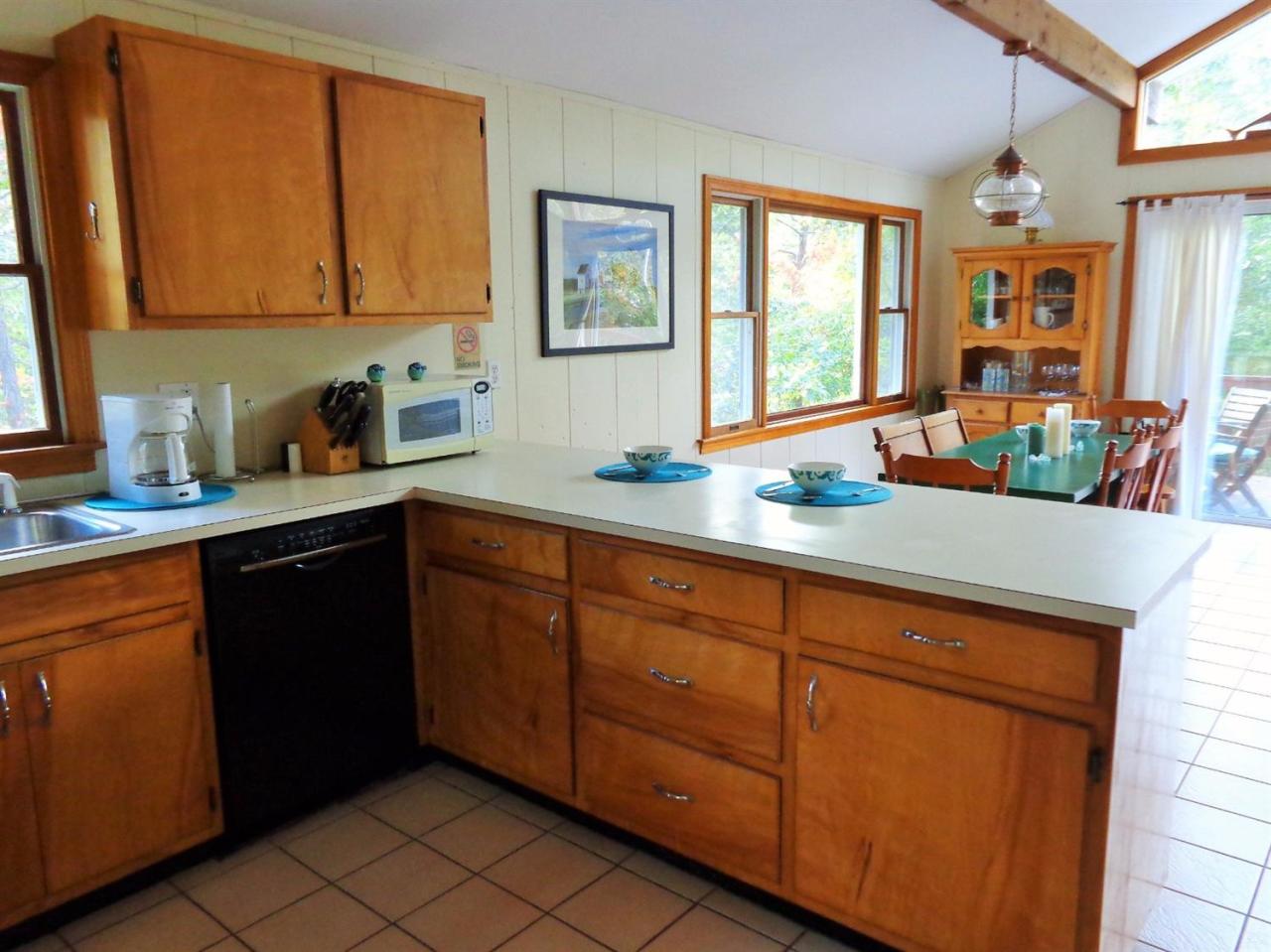 150 Cove View Road Wellfleet, MA 02667 - Photo 5 of 35 a kitchen with stainless steel appliances granite countertop a sink dishwasher stove and cabinets
