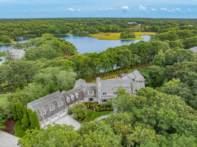 an aerial view of a house with a garden and lake view