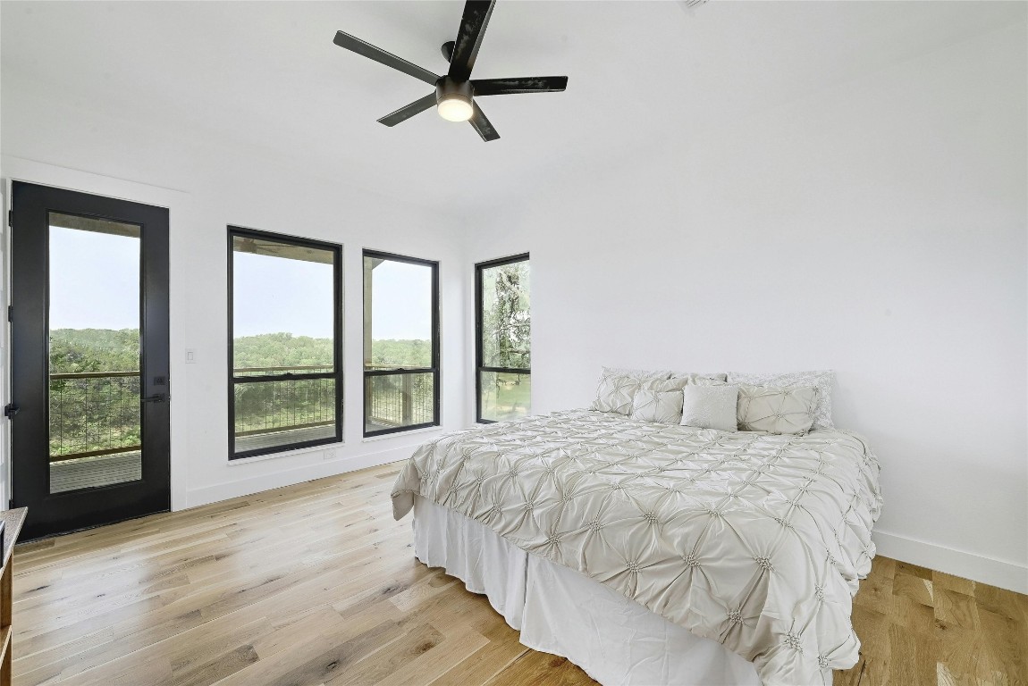 26701 Blue Cove Road Marble Falls, TX 78654 - Photo 11 of 27 a bedroom with a large bed and a large window