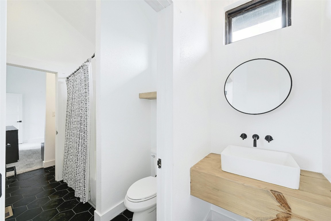 26701 Blue Cove Road Marble Falls, TX 78654 - Photo 20 of 27 a bathroom with a toilet a sink and a mirror