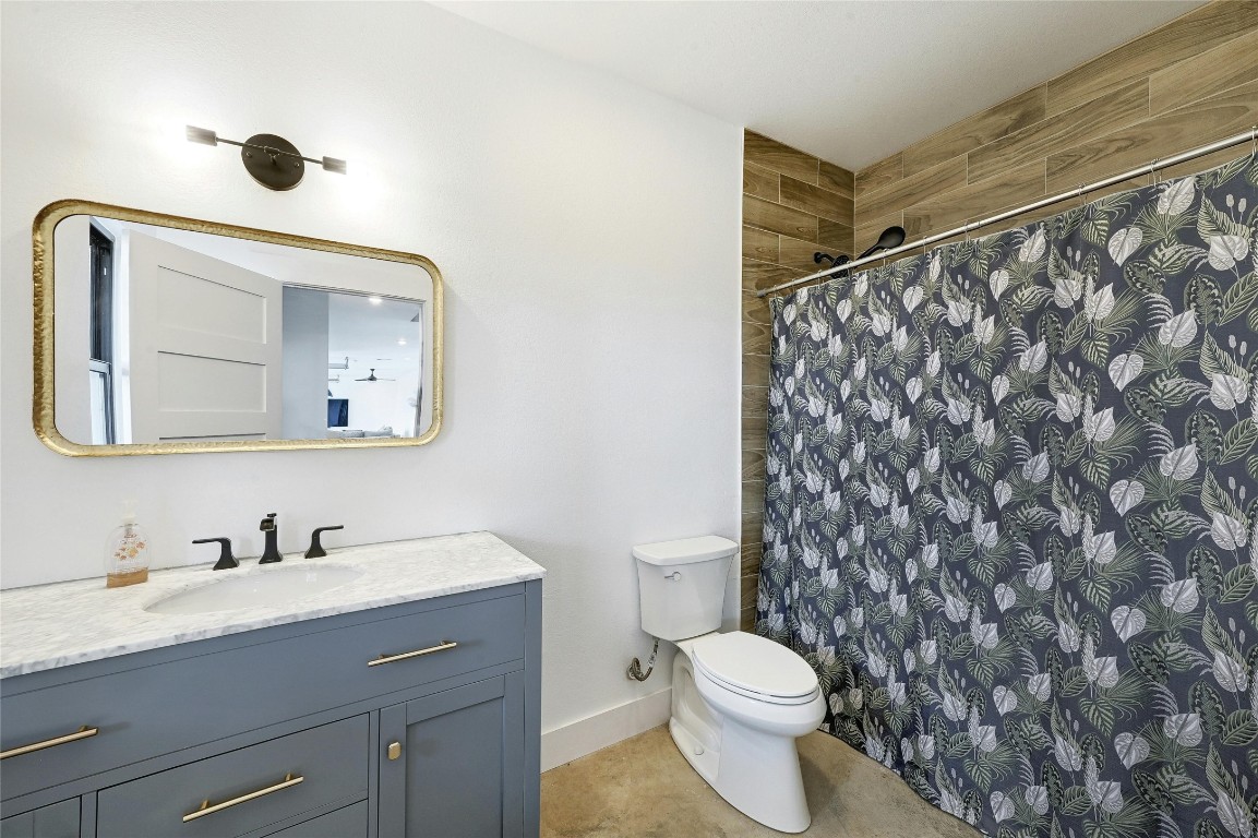 26701 Blue Cove Road Marble Falls, TX 78654 - Photo 22 of 27 a bathroom with a granite countertop sink mirror vanity and toilet