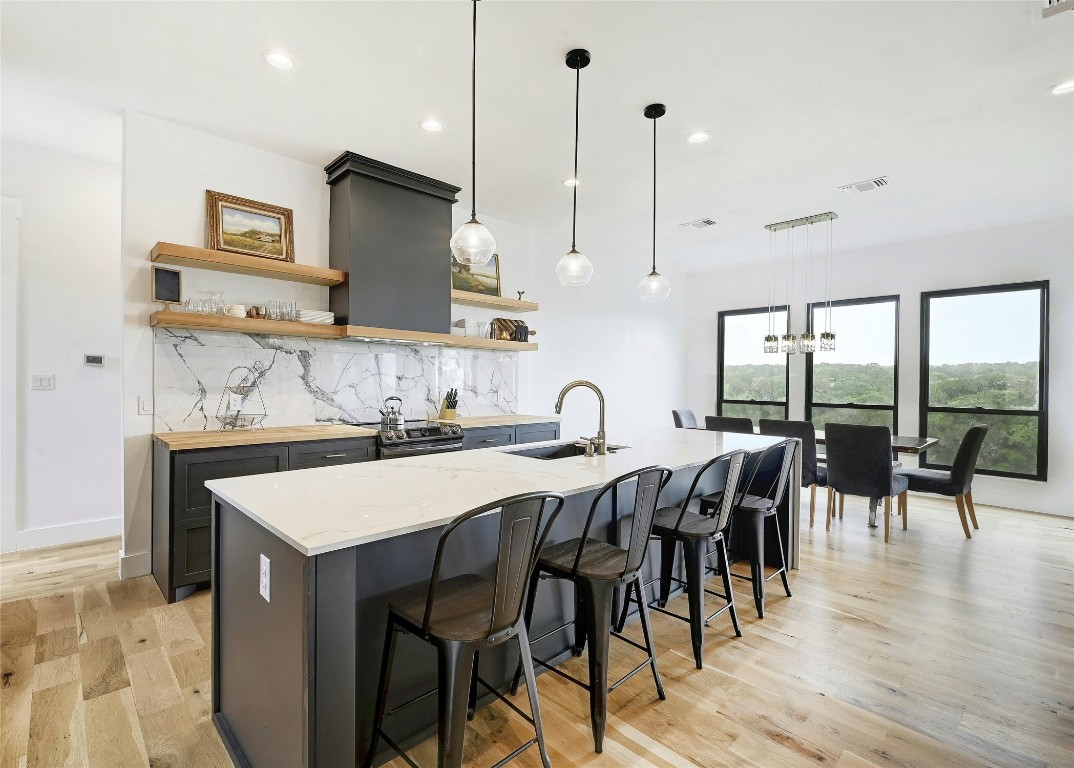 26701 Blue Cove Road Marble Falls, TX 78654 - Photo 8 of 27 a kitchen with stainless steel appliances granite countertop a stove a sink a oven a dining table and chairs with wooden floor