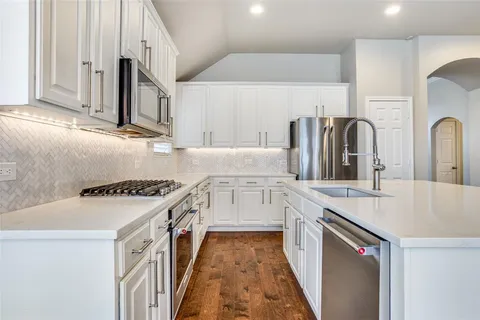 a kitchen with stainless steel appliances granite countertop a sink stove and refrigerator
