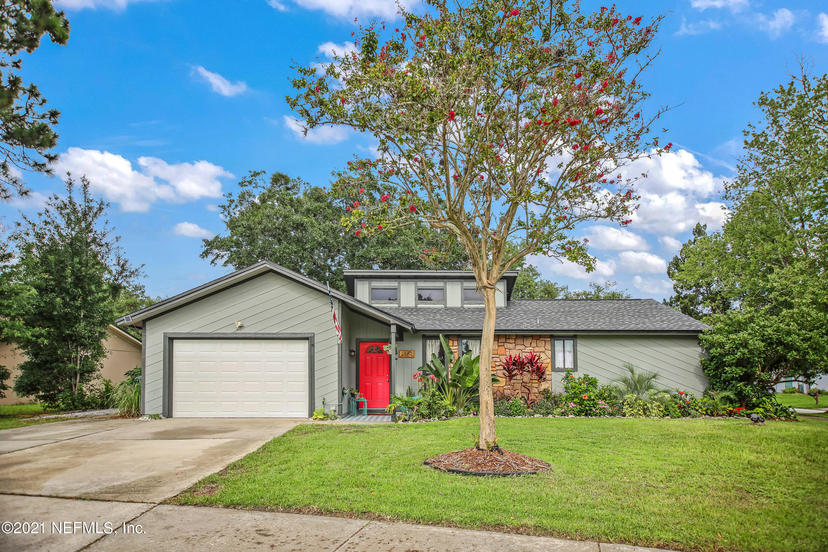 2587 Summer Tree Road East Jacksonville, FL 32246 - Photo 2 of 58 a front view of a house with a yard and garage