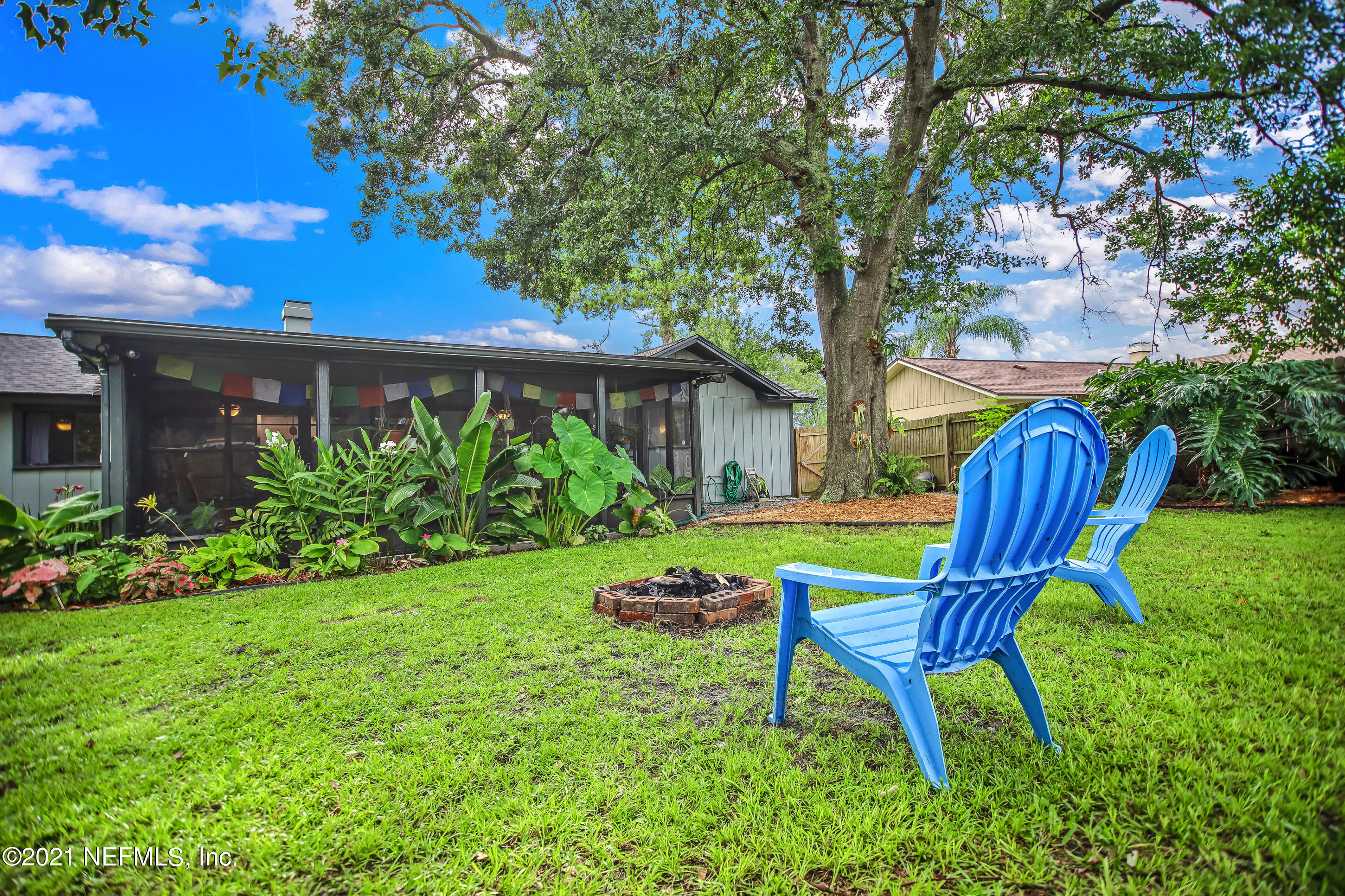 2587 Summer Tree Road East Jacksonville, FL 32246 - Photo 54 of 58 a view of a backyard with table and chairs potted plants and a large tree