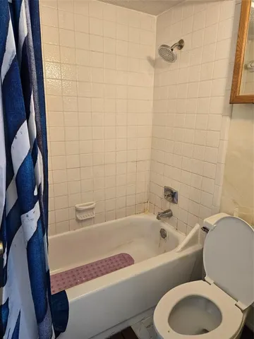 a view of an empty room with wooden floor and closet