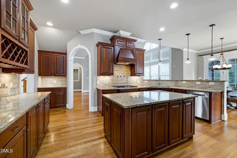 a kitchen with stainless steel appliances granite countertop a stove and a wooden cabinets