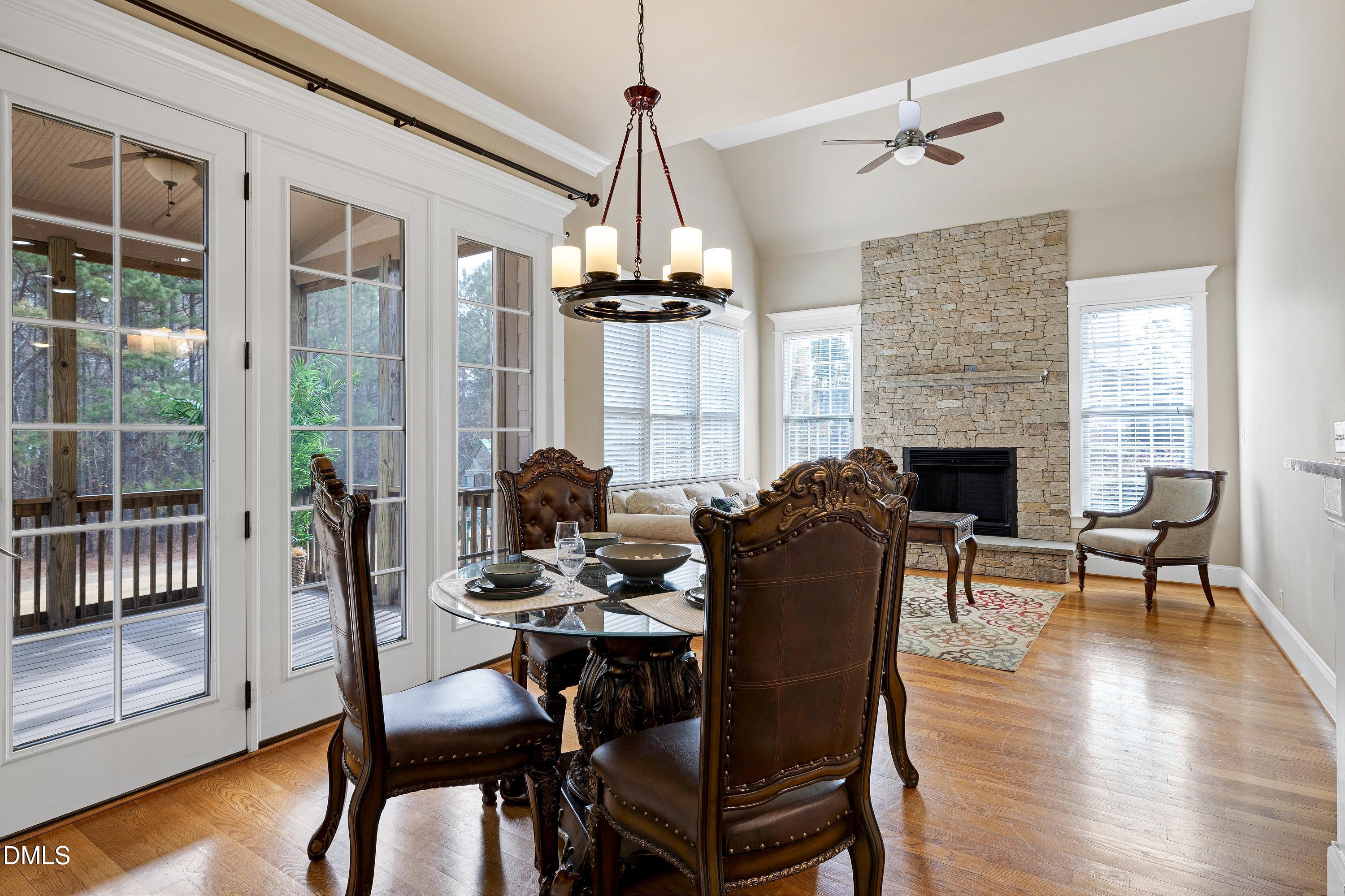 14212 Careme Court Wake Forest, NC 27587 - Photo 15 of 54 a dining room with furniture a chandelier and wooden floor