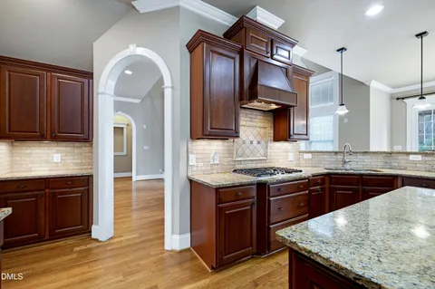 a kitchen with stainless steel appliances granite countertop a stove a sink and a refrigerator