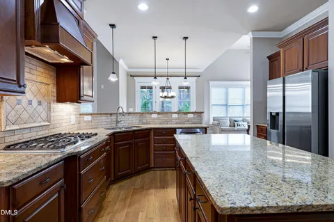 a kitchen with stainless steel appliances granite countertop a stove a sink a oven and a refrigerator