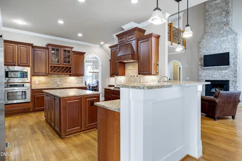 a kitchen with stainless steel appliances granite countertop a stove refrigerator and cabinets