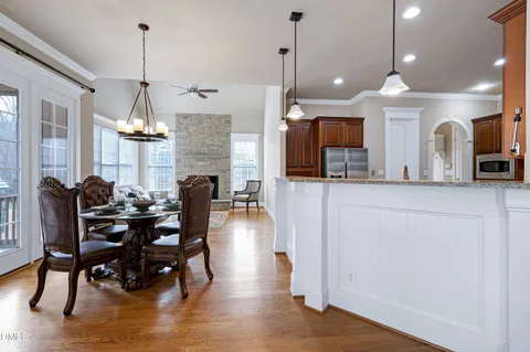 a view of a dining room and livingroom with furniture wooden floor a chandelier