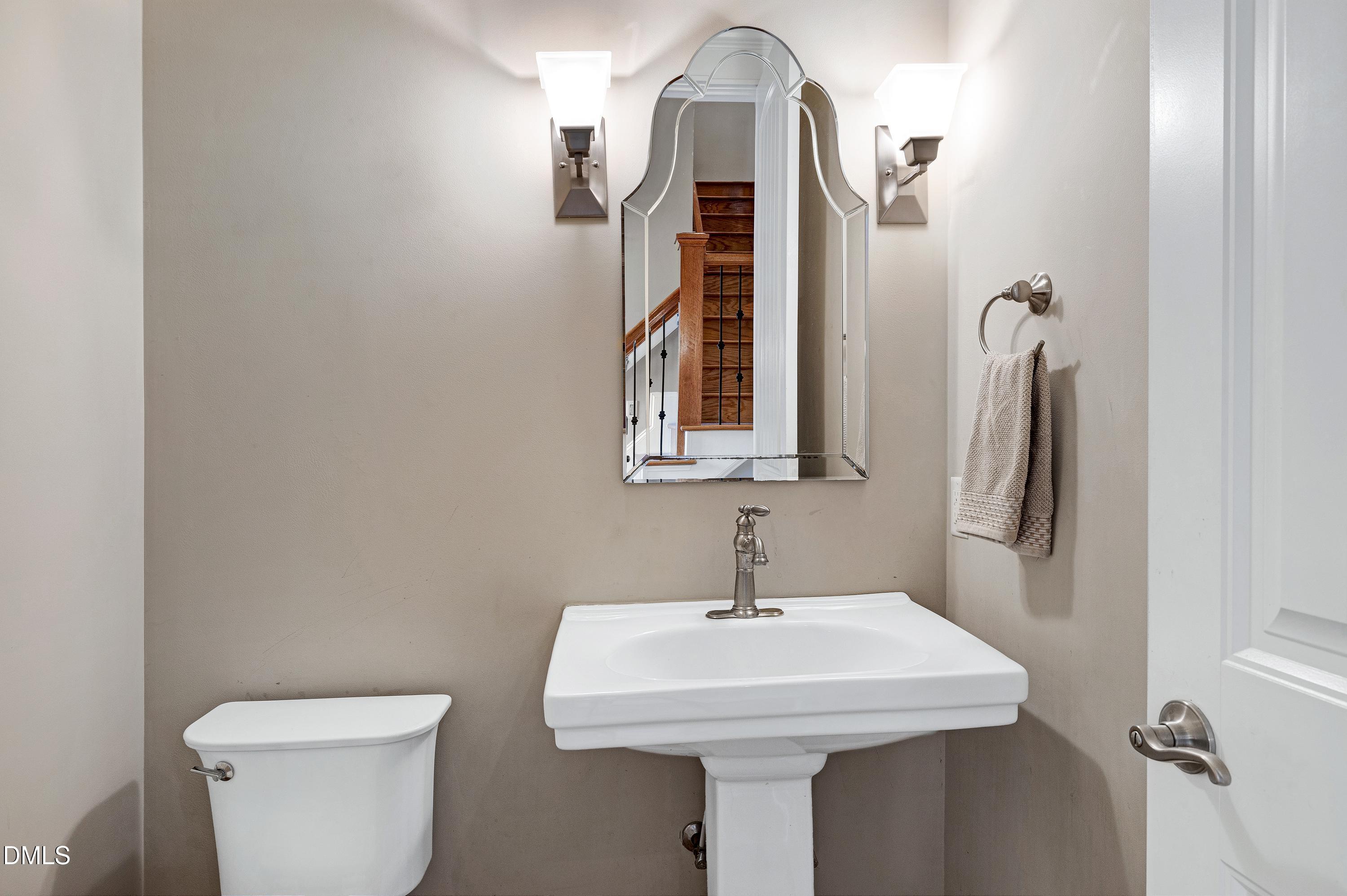 14212 Careme Court Wake Forest, NC 27587 - Photo 29 of 54 a bathroom with a toilet sink and mirror