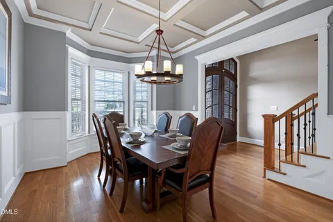 a dining room with furniture a chandelier and wooden floor