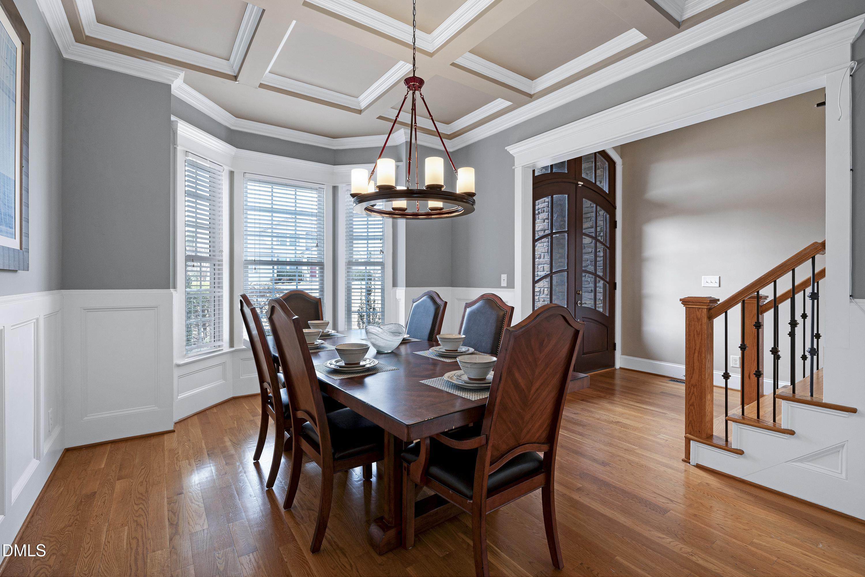14212 Careme Court Wake Forest, NC 27587 - Photo 5 of 54 a dining room with furniture a chandelier and wooden floor