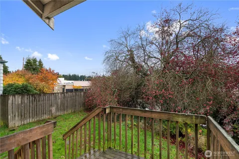 a view of deck with large trees and wooden fence