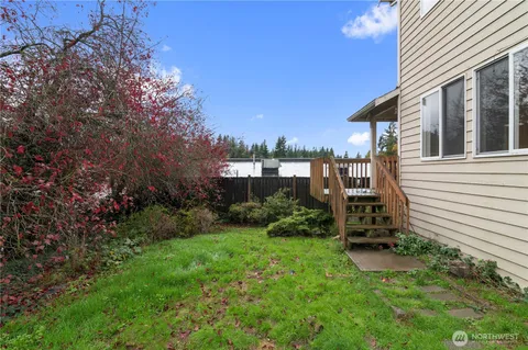 a view of a chair and table in backyard of the house