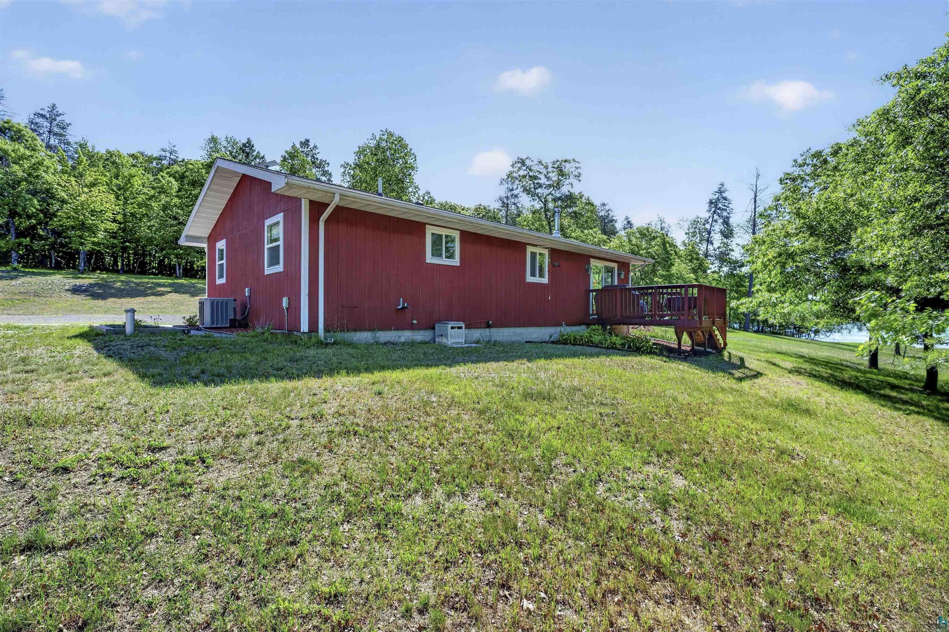 11702 East Mail Road Gordon, WI 54838 - Photo 7 of 60 Red exterior siding with white trim and a brown wooden deck
