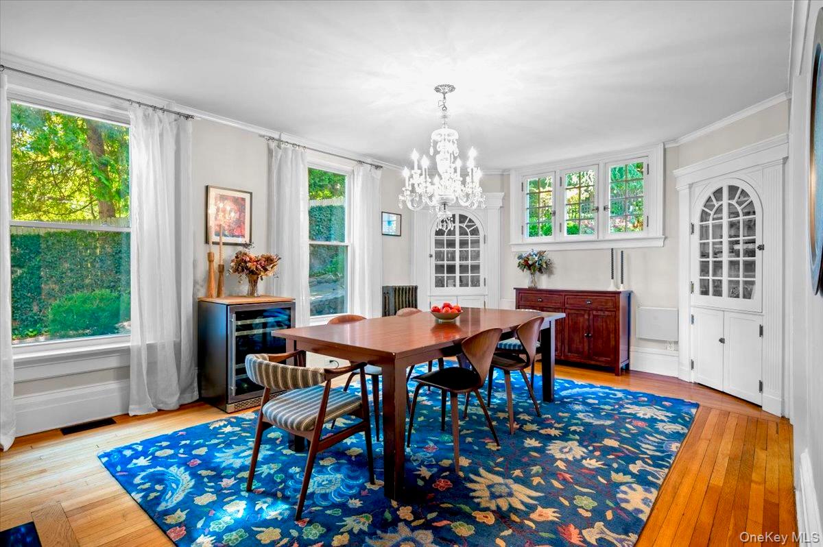 245 River Road Nyack, NY 10960 - Photo 13 of 45 Dining area featuring beverage cooler, light wood-style flooring, crown molding, and a chandelier