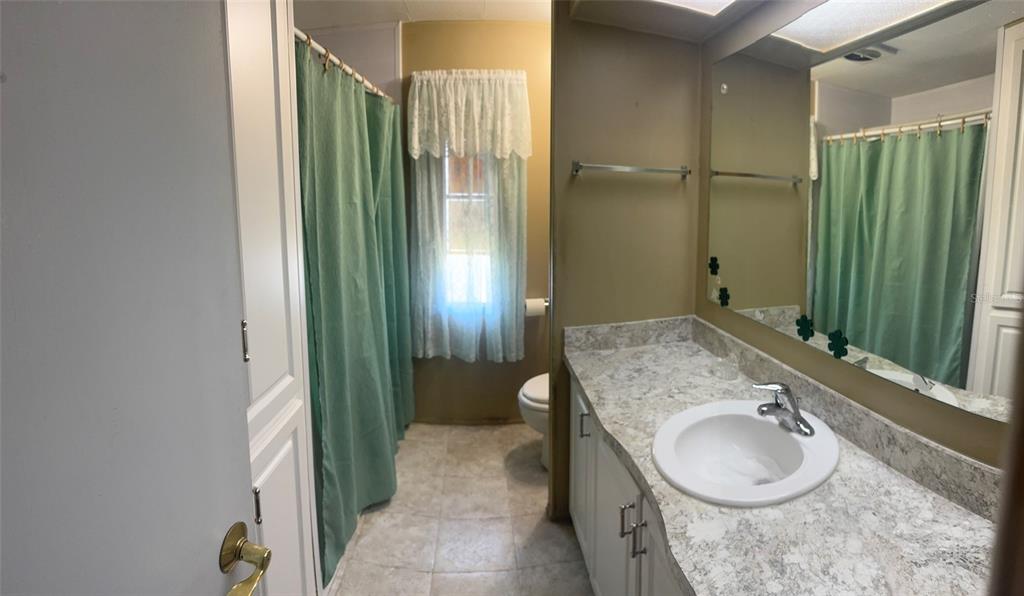 3301 Alt 19, Unit 314 Dunedin, FL 34698 - Photo 6 of 11 a bathroom with a granite countertop sink a mirror and a shower
