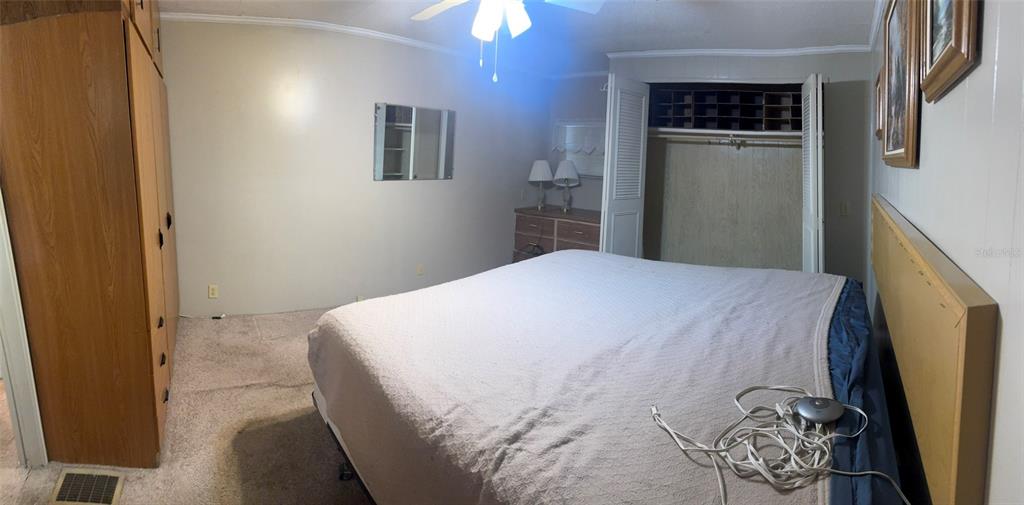 3301 Alt 19, Unit 314 Dunedin, FL 34698 - Photo 8 of 11 a bedroom with a bed and a chandelier