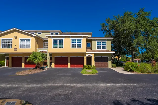 a view of a patio with couches table and chairs potted plants and palm tree