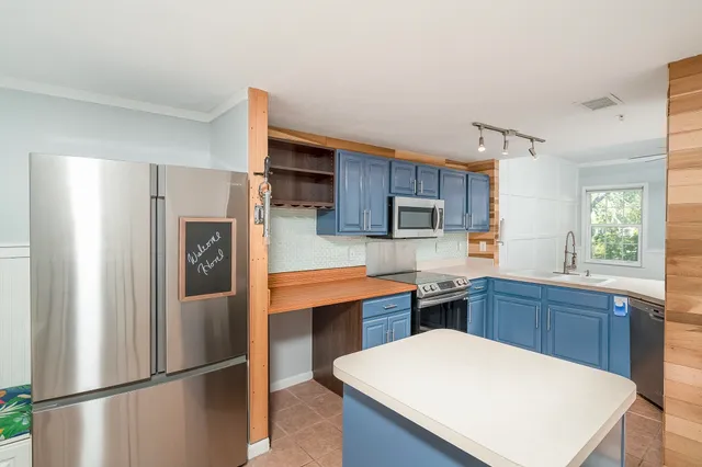 a kitchen with stainless steel appliances kitchen island granite countertop a stove and a microwave